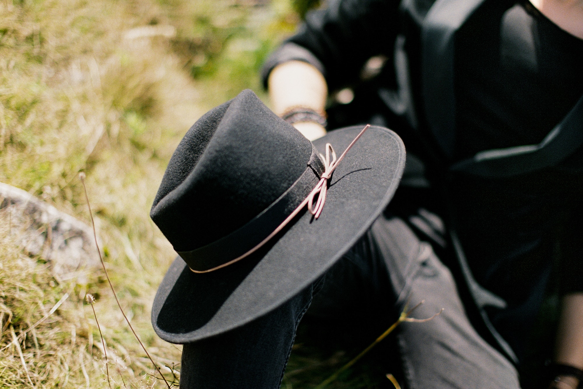 Black hat on the knee of a man. Close-up