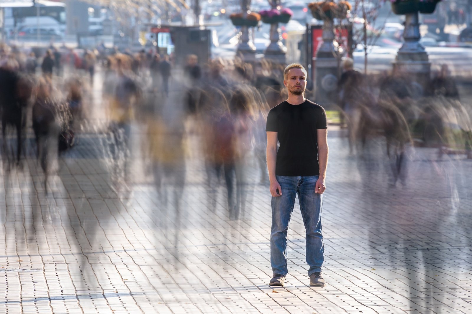 The man stands on the crowded street.